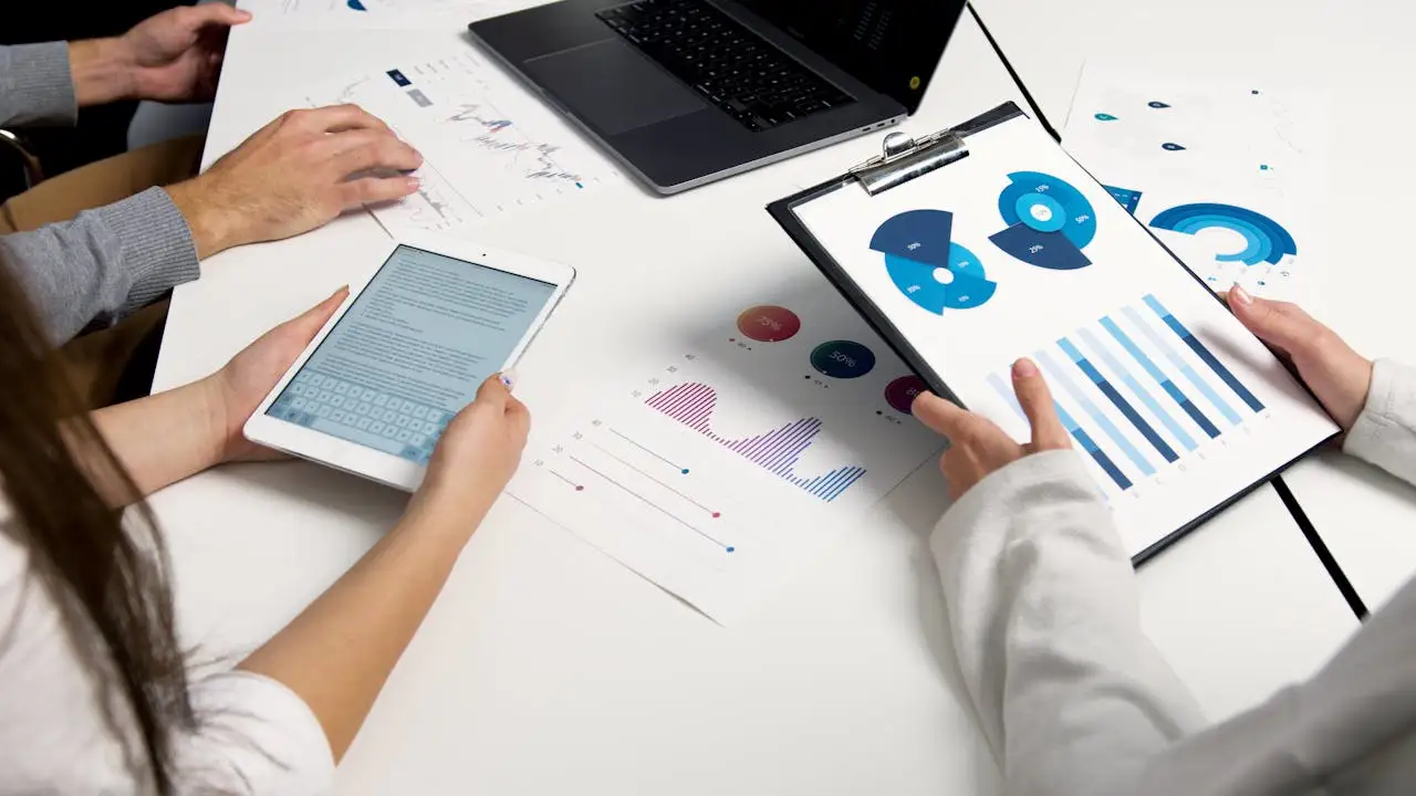 Team members review spend and diversity charts on tablet, laptop and printed reports