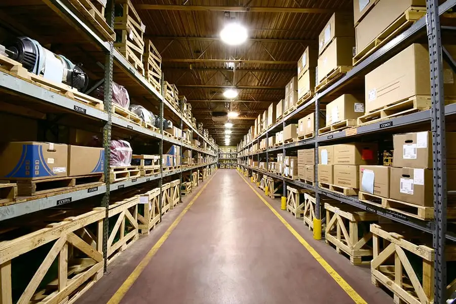 Warehouse aisle stacked with boxed inventory on industrial shelving